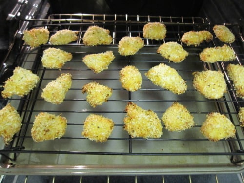 Breaded chicken bites baking on a wire rack in the oven, coated with a crispy crumb topping.