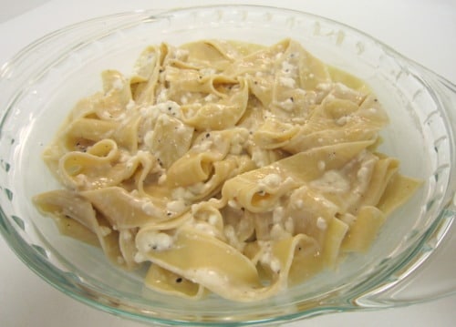Creamy noodles mixed with sour cream and cheese in a glass baking dish.