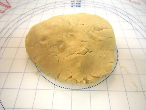 Ball of cookie dough on a pastry mat with measurement markings.