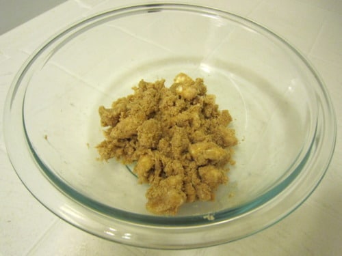 Brown sugar and butter mixture in a clear glass bowl on a white surface.