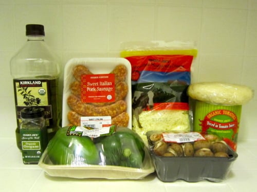 Ingredients for cast iron skillet deep dish sausage pizza including sausage, bell peppers, mushrooms, cheese, pizza dough, olive oil, and oregano.