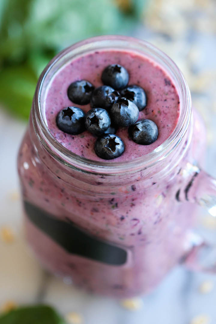 Blueberry green smoothie in a mason jar topped with fresh blueberries.