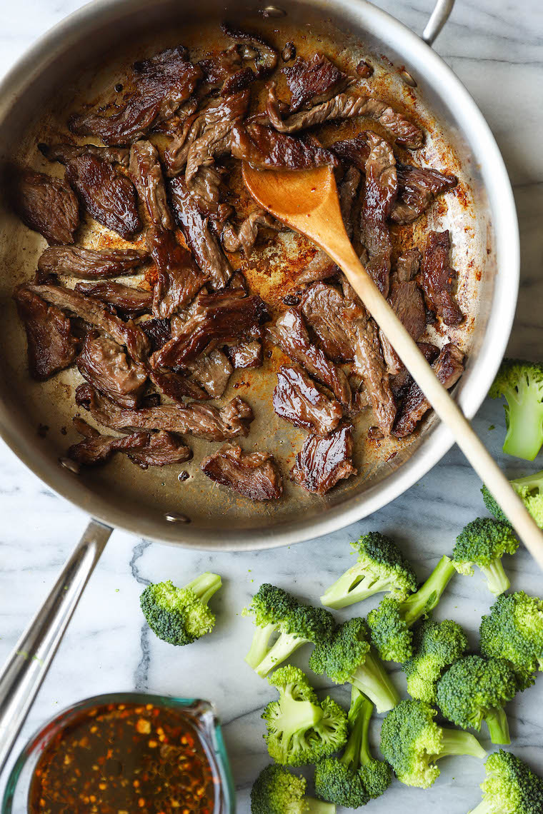 Tender slices of beef are coated in a glossy, dark brown sauce and mixed with bright green, crisp broccoli florets.