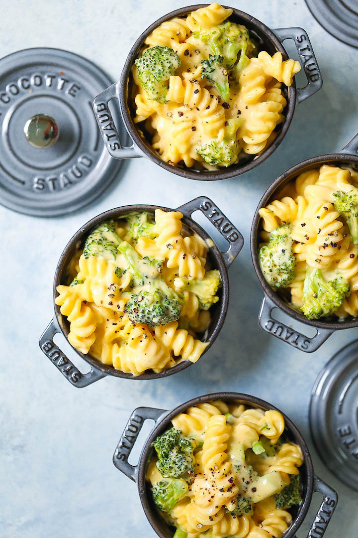 Mini Staub cocottes filled with creamy broccoli mac and cheese made with rotini pasta and topped with cracked black pepper.