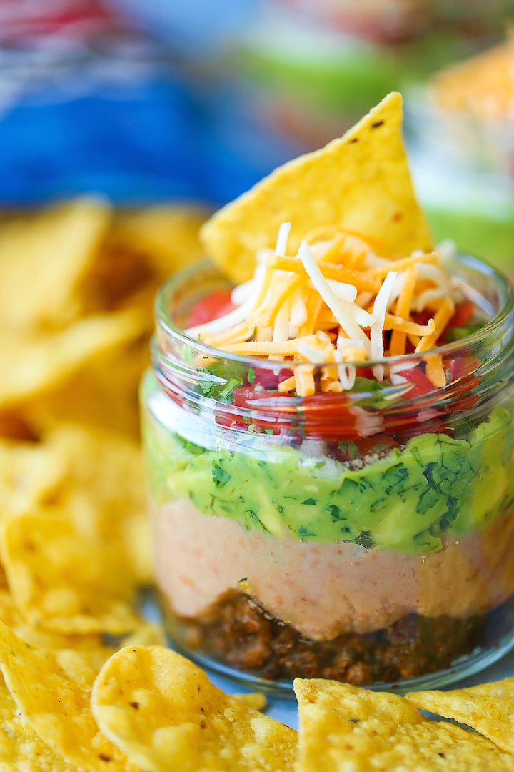 5-Layer Mason Jar Taco Dip - Everyone’s favorite dip in mason jar form! Everything is layered in individual jars so it makes for the easiest serving! Loaded with taco beef, refried beans, guacamole, pico de gallo, and cheese!