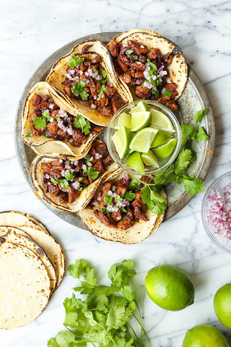 Mexican street tacos recipe with carne asada steak, onion, cilantro, and lime on warm tortillas