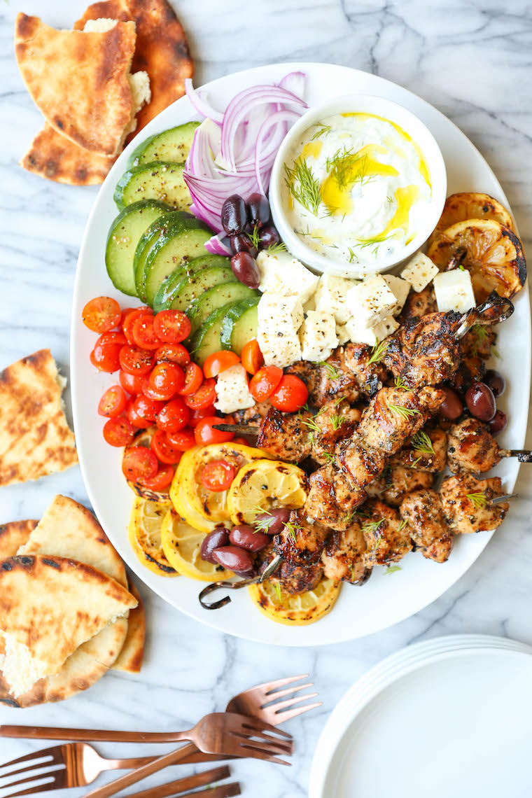 Greek chicken kabobs on platter with tzatziki sauce